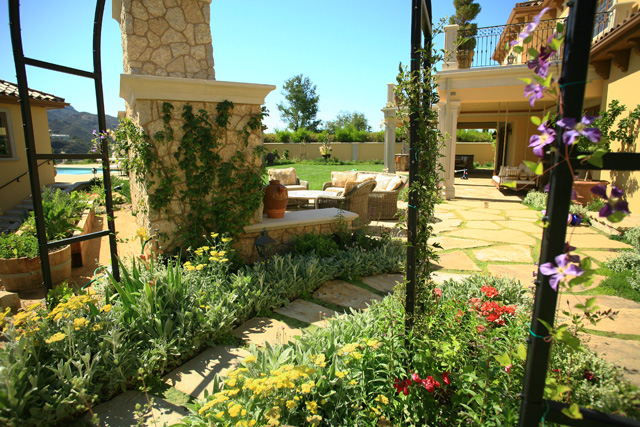 backyard rock walkway through yellow and red flowers