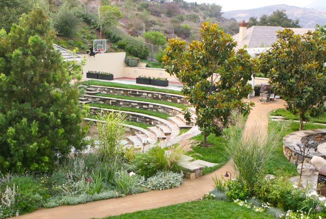 sand path through green landscape with stone amphitheater